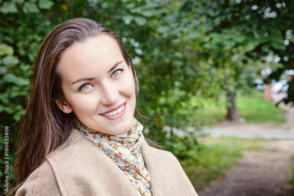 Smiling woman with a perfect smile, walking in the coat in autumn Park and looking at camera. Smiling woman with a perfect smile, walking in the coat in autumn Park and looking at camera.