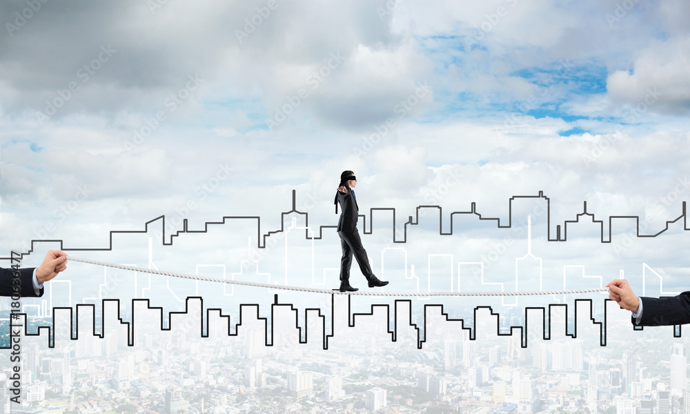 Business concept of risk support and assistance with man balancing on rope Business concept of risk support and assistance with man balancing on rope