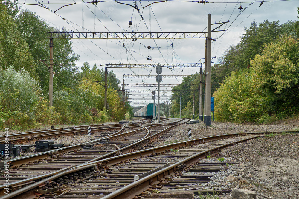 Railway station and train in the background of a forest and a beautiful sky. Landscape with the railway and train, Travel.