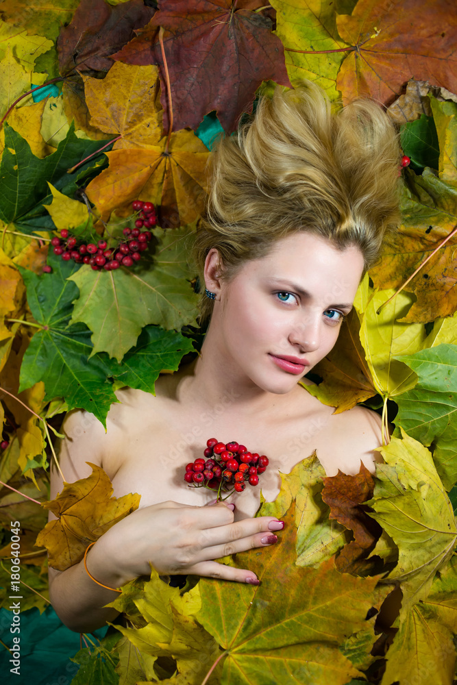 The girl lays on autumn leaves