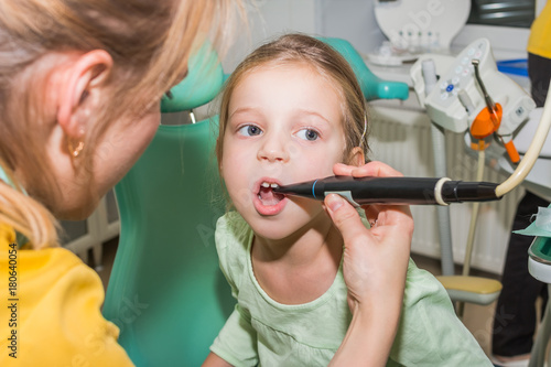 kid in dentist clinic.Dental health. Female dentist curing a child patient in doctor's consulting room. Pediatric dentist. Medical inspection. Health care.dentist examining llittle girl's teeth