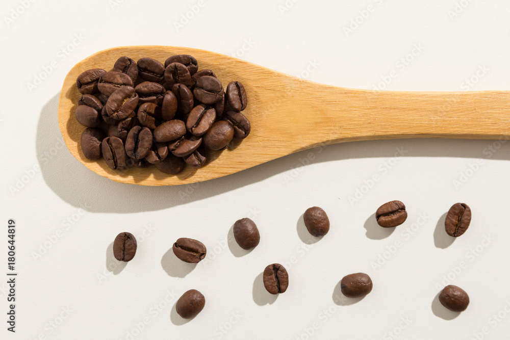 Fototapeta premium coffee beans seed. Healthy grains on a wooden spoon. White background.