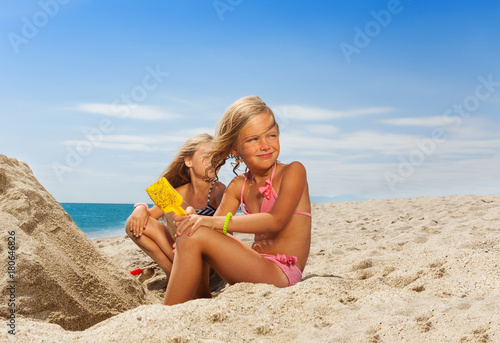 Adorable girl playing with sand at the beach