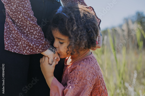 young girl kissing mothers hand