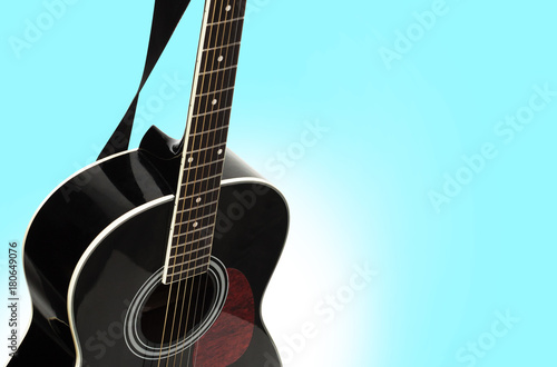Black acoustic guitar on a blue background