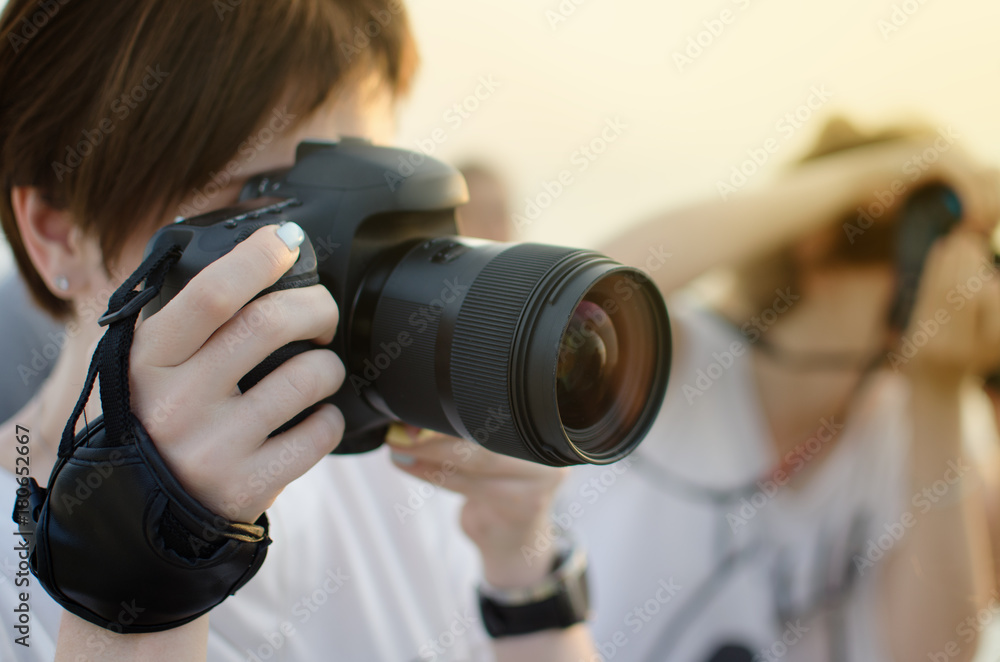 Girl with a big black camera in the setting sun Girl with a big black camera in the setting sun