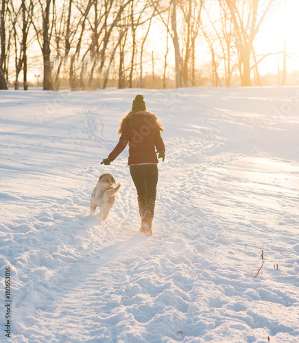 Portrait of a young woman with dog on winter walk.