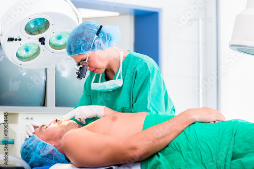 Orthopedic surgeon doctor operating patient in surgery or hospital