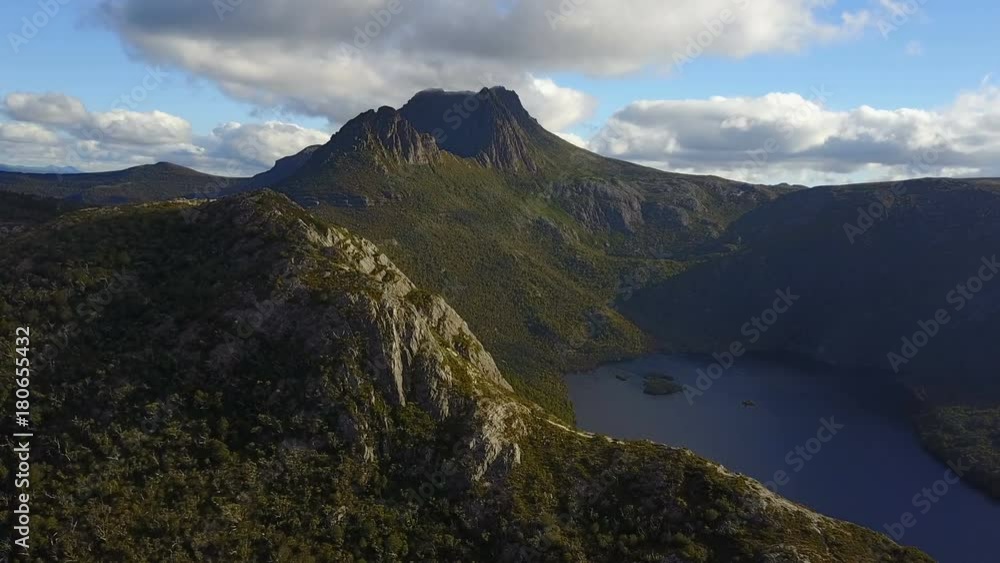 Mountain and lake in Tasmania with clouds in sky Mountain and lake in Tasmania with clouds in sky