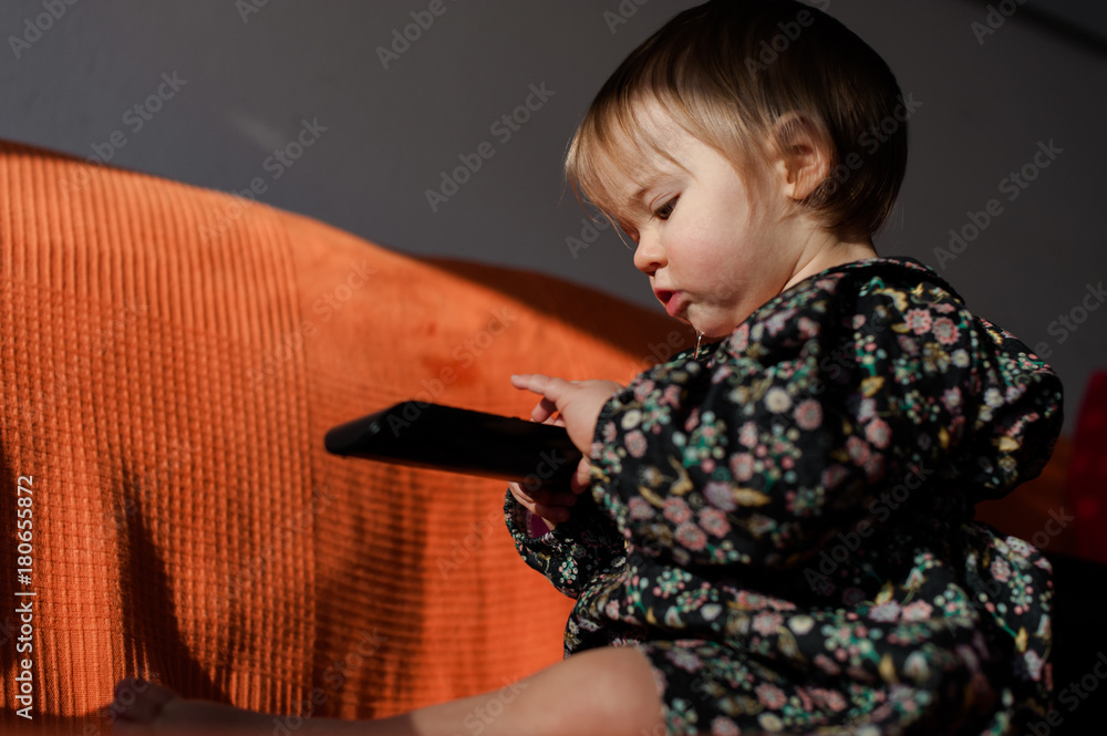 girl on an orange couch with remote control girl on an orange couch with remote control