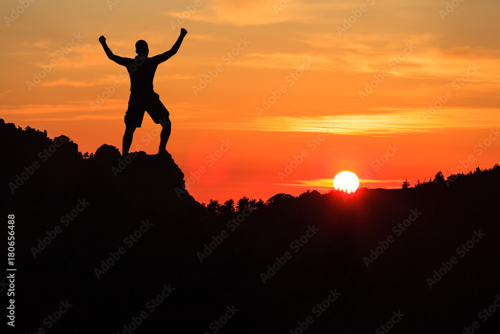 Man hiking climbing silhouette in sunset mountains