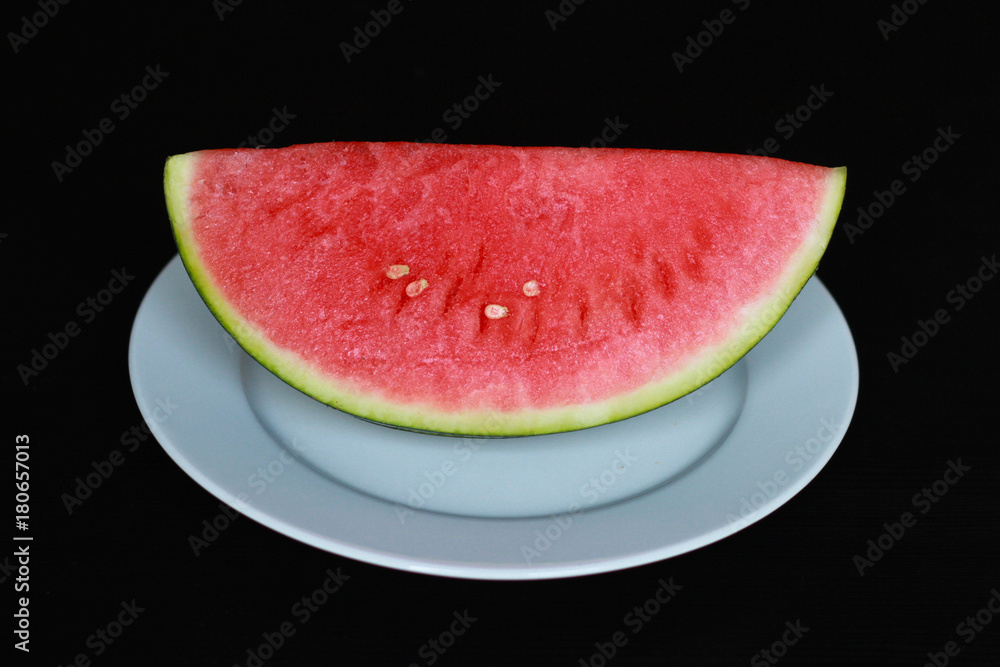 slice of red watermelon pitted on a white plate slice of red watermelon pitted on a white plate