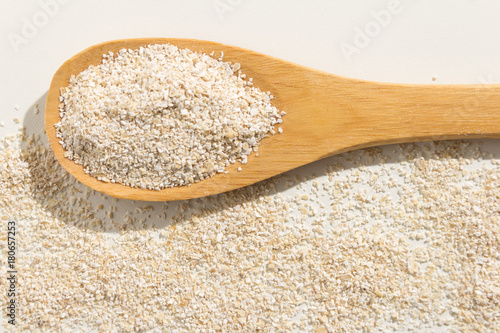 Oat cereal grain. Healthy grains on a wooden spoon. White background.