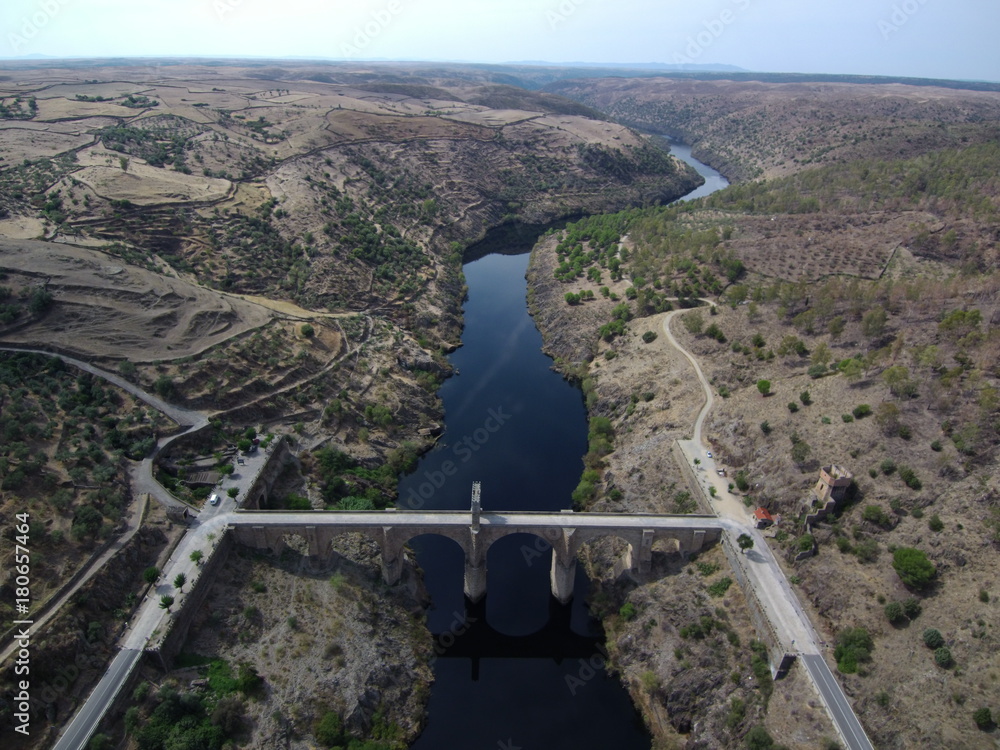 Obraz premium Puente romano de Alcántara, pueblo de Cáceres en Extremadura (España) situado en la orilla del río Tajo, confluencia con el río Alagón, cerca de Portugal. Fotografia aerea con Drone