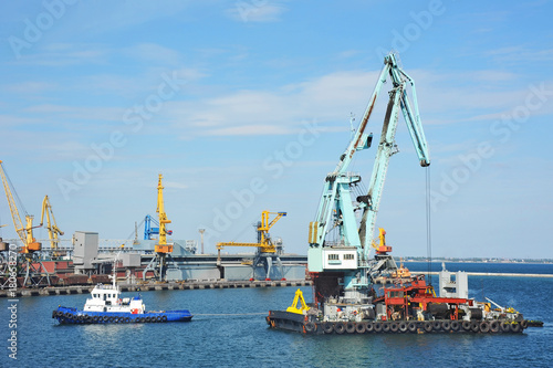 Tugboat assisting floating cargo crane