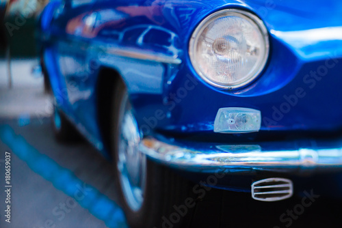 Close-up of front headlight of blue vintage car © bodiaphoto