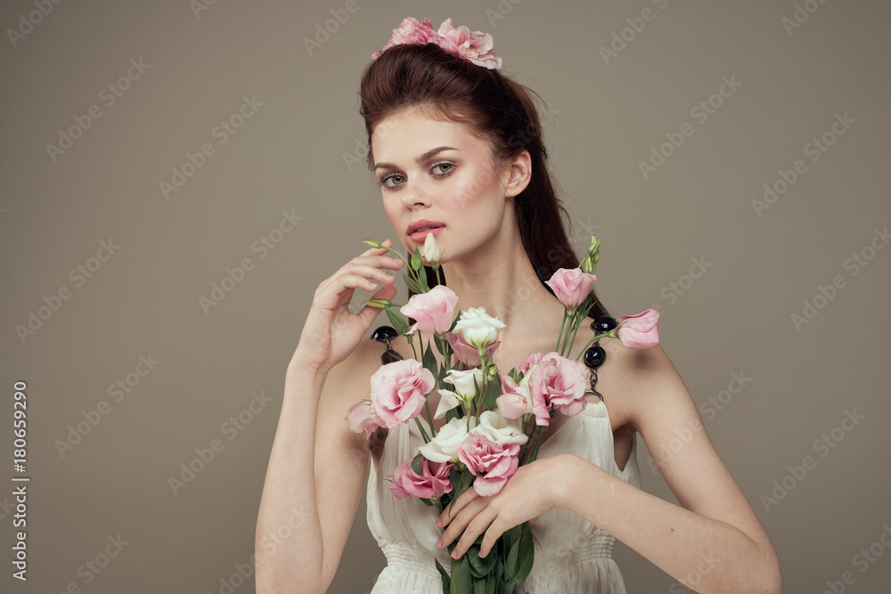 beautiful woman with a bouquet of flowers on a gray background beautiful woman with a bouquet of flowers on a gray background