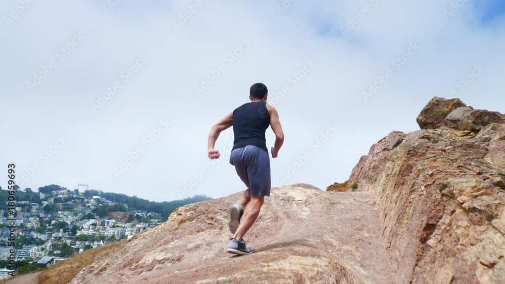 Fit Asian man trail running. The skyline of San Francisco can be seen in the background. Fit Asian man trail running. The skyline of San Francisco can be seen in the background.