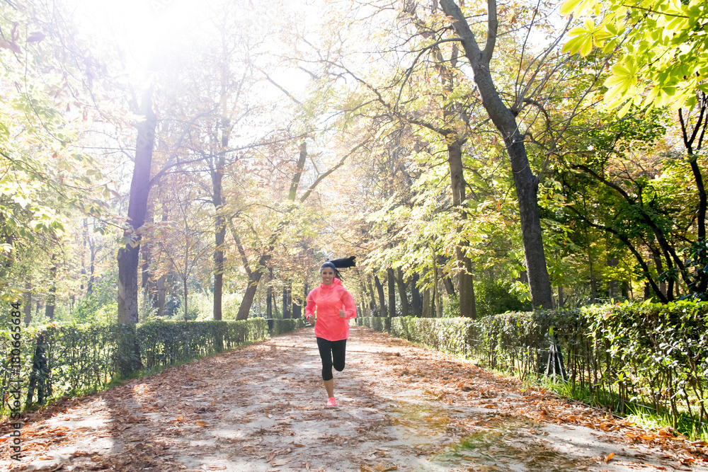 attractive and happy runner woman in Autumn sportswear running a