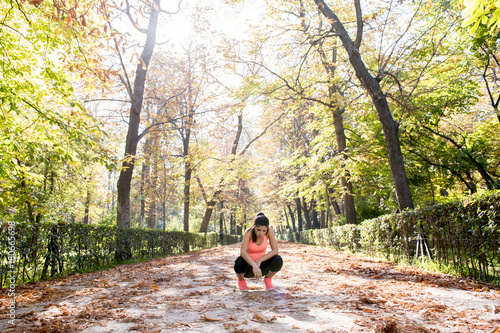 Fototapeta Naklejka Na Ścianę i Meble -  attractive sport woman in runner sportswear breathing gasping and taking a break tired and exhausted after running workout on Autumn park