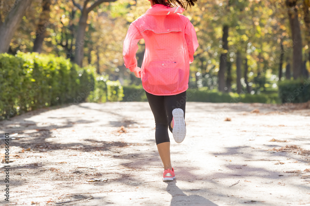 Fototapeta premium attractive and happy runner woman in Autumn sportswear running and training on jogging outdoors workout in city park