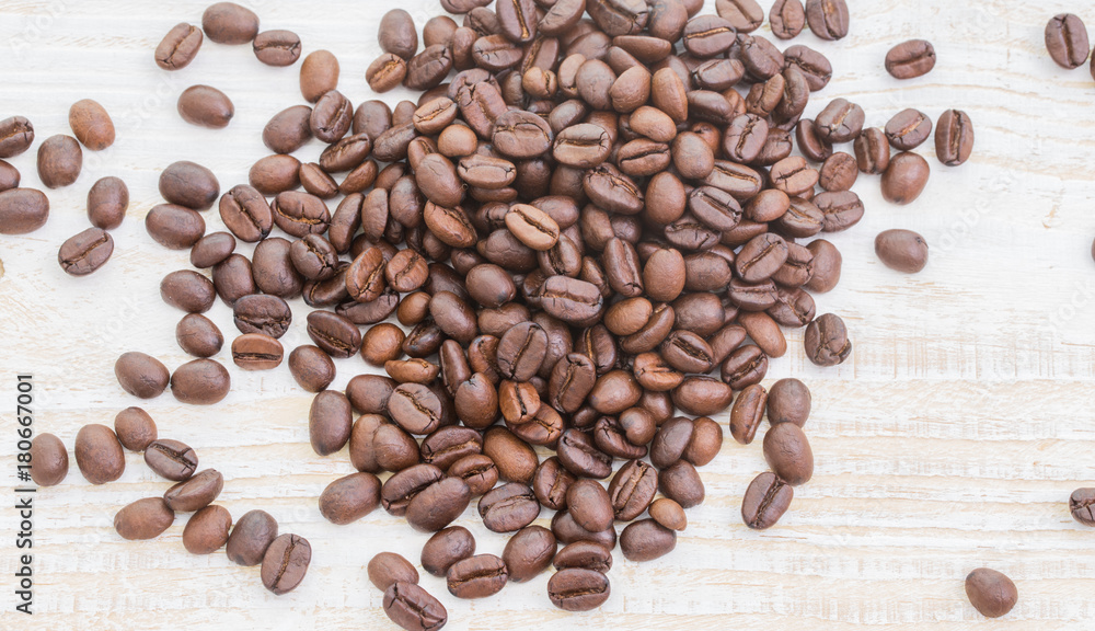 Naklejka premium Coffee beans on wood background