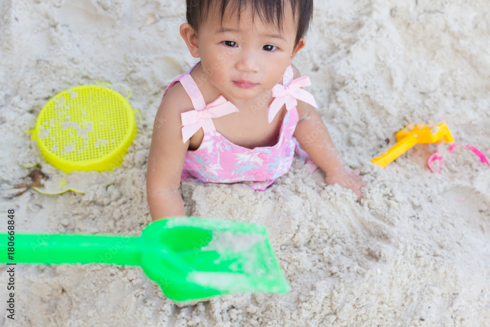 Asian cute baby girl playing toys on sand beach. Asian cute baby girl playing toys on sand beach.