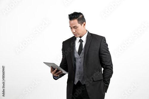 Business man standing playing tablet on white background