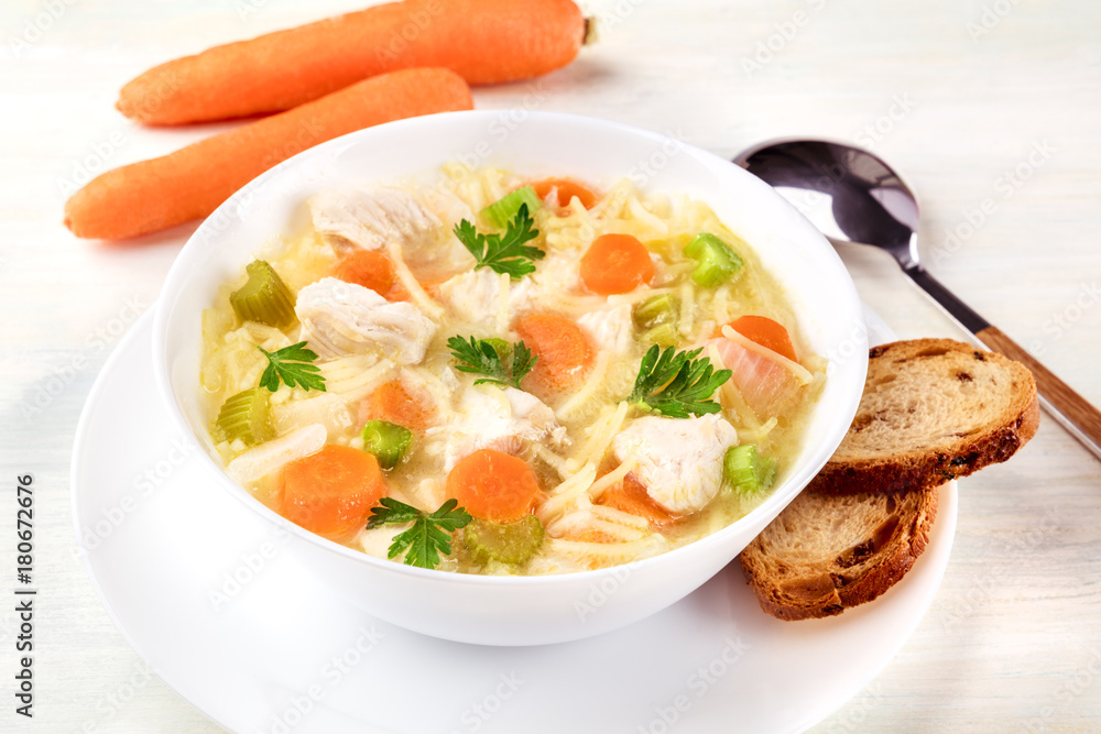 Chicken soup with noodles, bread, and copy space Chicken soup with noodles, bread, and copy space