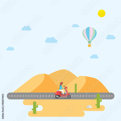 Woman driving scooter across the desert at the afternoon