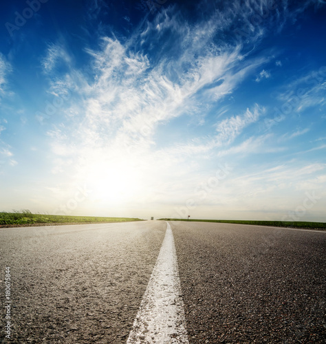 sunset in deep blue sky over asphalt road