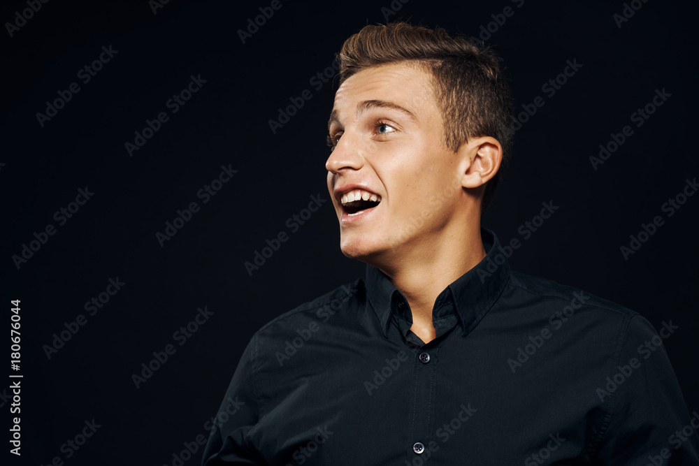 man in black shirt on black background is surprised by close-up man in black shirt on black background is surprised by close-up