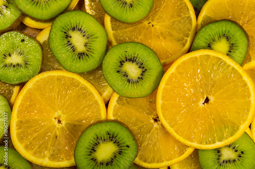 Sliced kiwi fruits and oranges for background