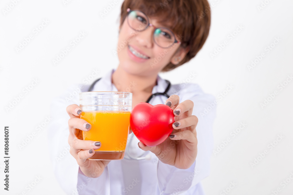 Happy woman doctor holding the red heart and orange juice. Isolated on white background. Studio lighting. Concept for healthy and medical Happy woman doctor holding the red heart and orange juice. Isolated on white background. Studio lighting. Concept for healthy and medical