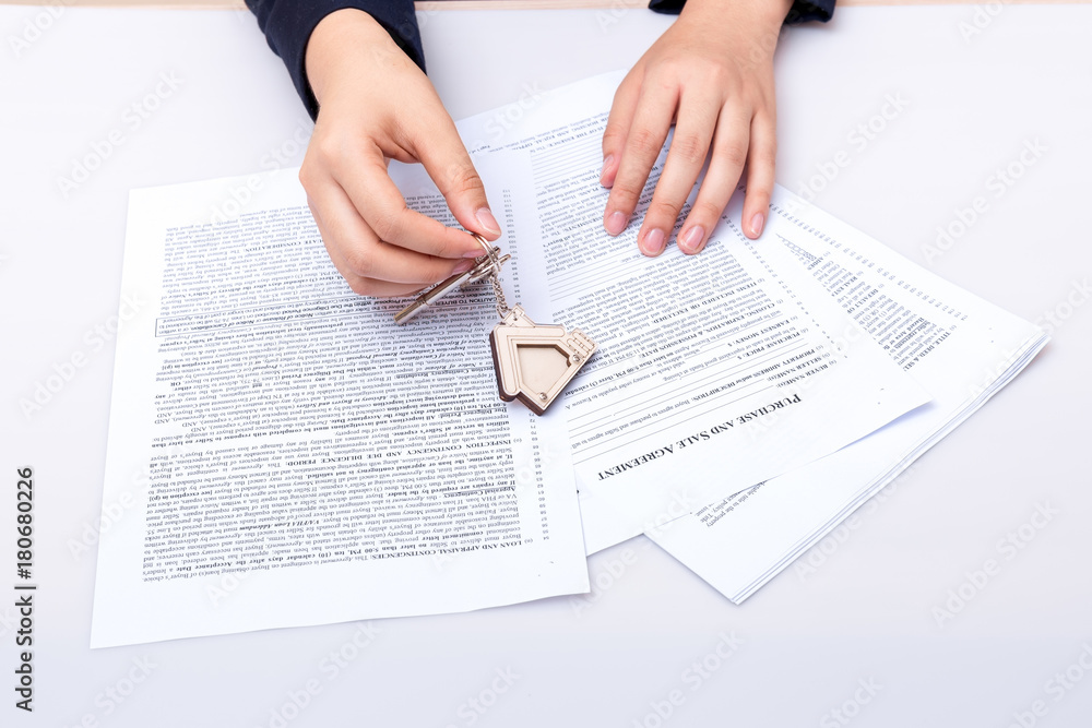 Woman hand and home key. Signed contract and keys of the property with documents. Concept for real estate business. Woman hand and home key. Signed contract and keys of the property with documents. Concept for real estate business.