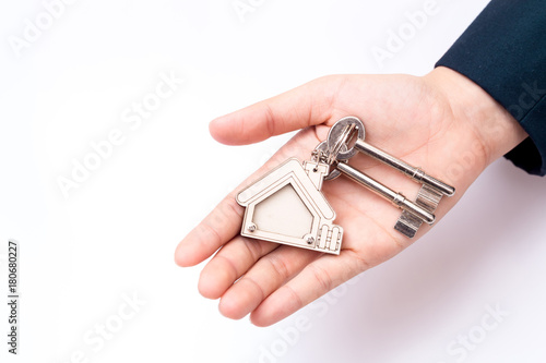 Home seller holding home key. Concept for real estate business.