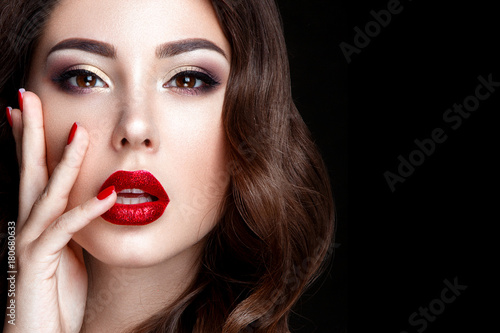 Fashion woman portrait on black background with red shiny lips.