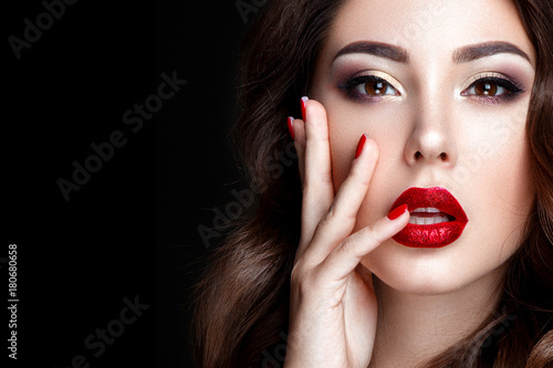 Fashion woman portrait on black background with red shiny lips.