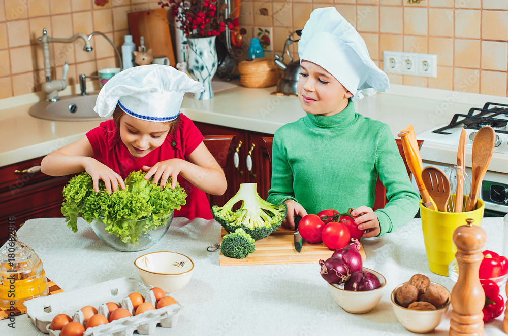 happy family funny kids are preparing the a fresh vegetable salad in the kitchen happy family funny kids are preparing the a fresh vegetable salad in the kitchen
