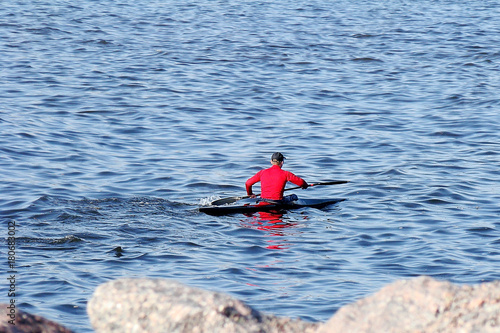 a man in a red jacket sailing kayak