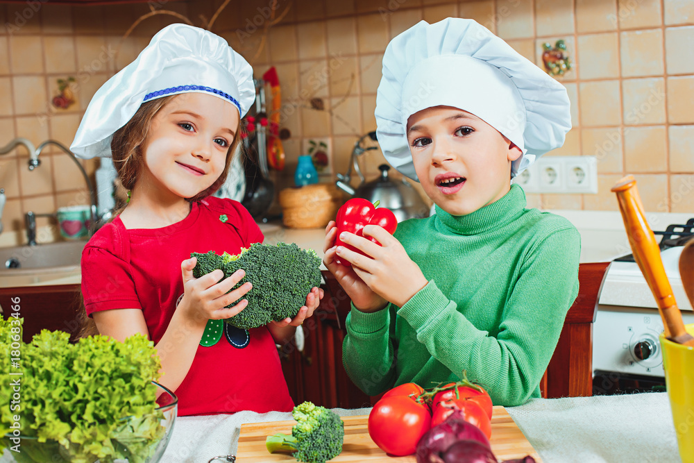 happy family funny kids are preparing the a fresh vegetable salad in the kitchen happy family funny kids are preparing the a fresh vegetable salad in the kitchen