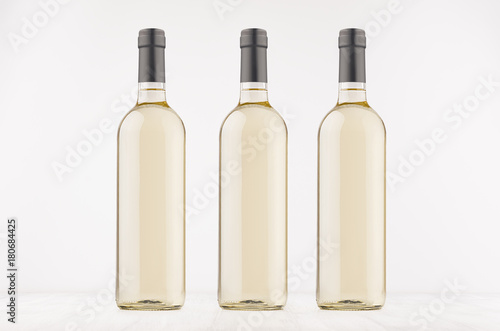 Wallpaper Mural Three transparent wine bottles with white wine on white wooden board, mock up. Template for advertising, design, branding identity. Torontodigital.ca