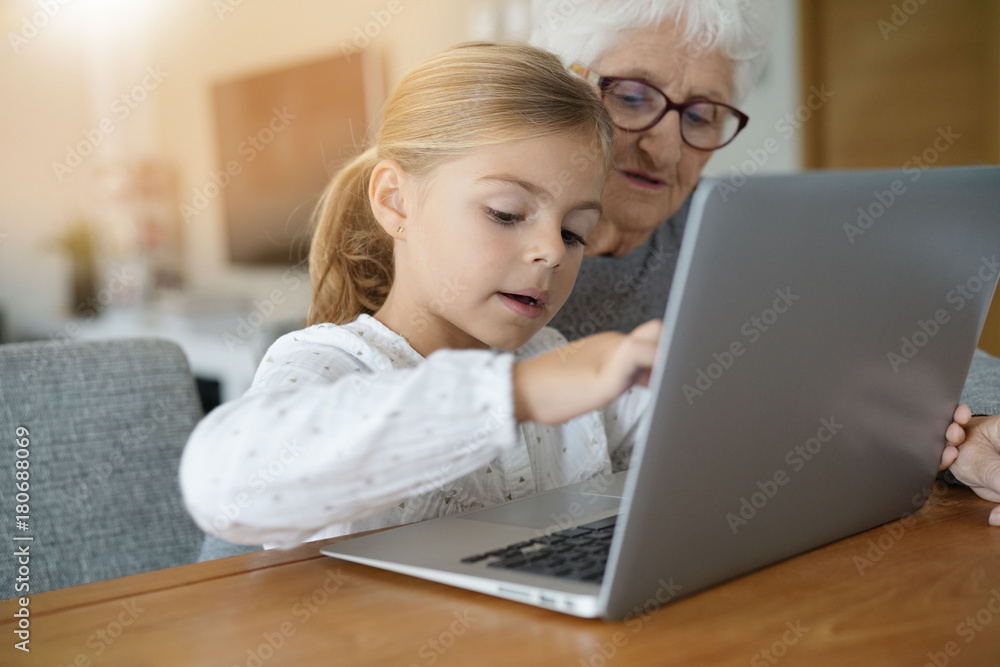Little girl with grandmother using laptop computer Little girl with grandmother using laptop computer