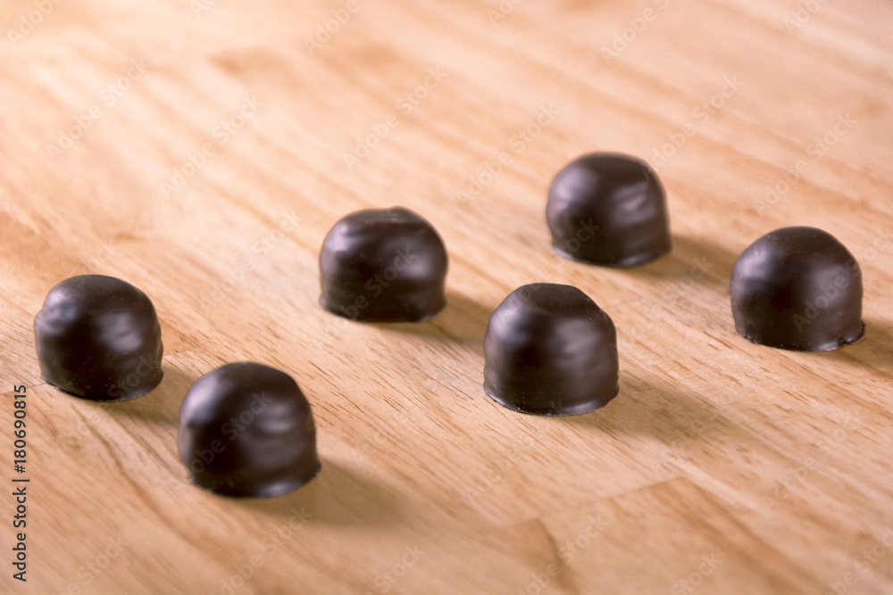 Set of darkness chocolate pralines bonbon on wood table Set of darkness chocolate pralines bonbon on wood table