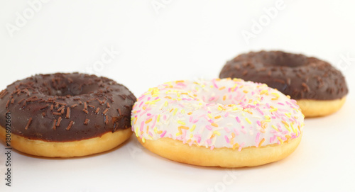 Three sweet white and chocolate donuts are on white table