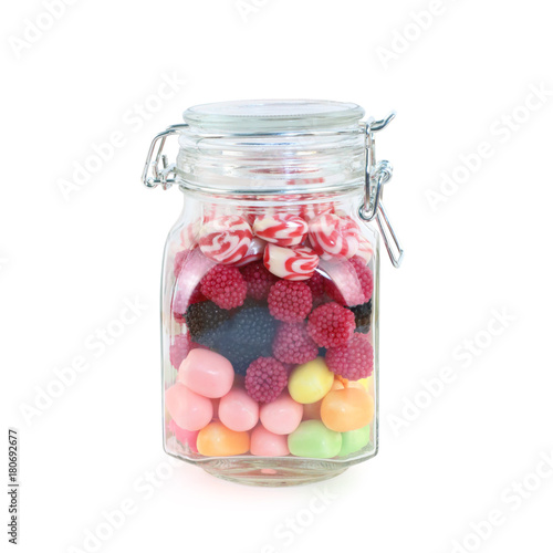Glass jar with many bright sweet candies isolated on white background