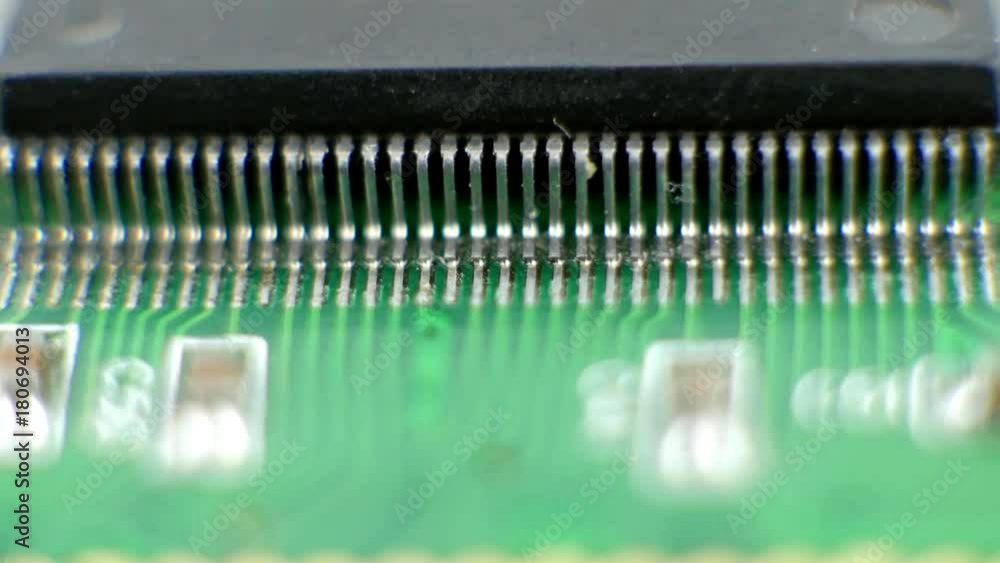 Electonic components microchips or cpu leg contacts. Integrated semiconductor microchip. Microprocessor on green circuit board. System board with microchips and transistors Electonic components microchips or cpu leg contacts. Integrated semiconductor microchip. Microprocessor on green circuit board. System board with microchips and transistors