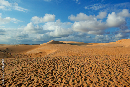 cloudy blue sky over desert dunes