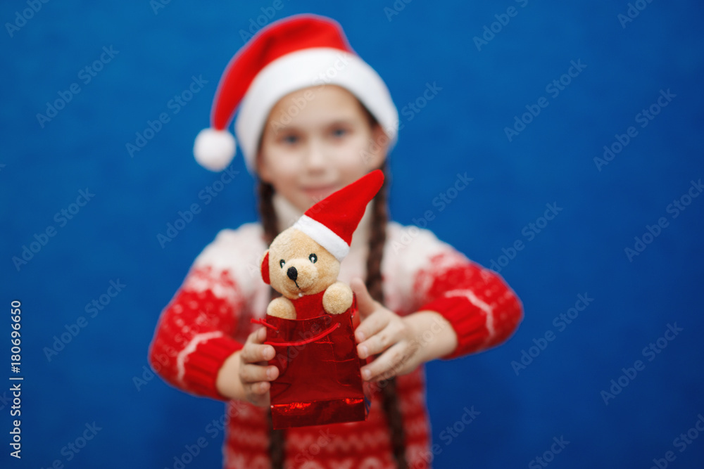 Cute little girl with toy on background of blue color. Christmas concept Cute little girl with toy on background of blue color. Christmas concept
