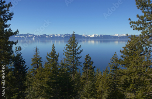 Lake Tahoe, California with pine trees in front and the Sierra, Nevada mountains in the background